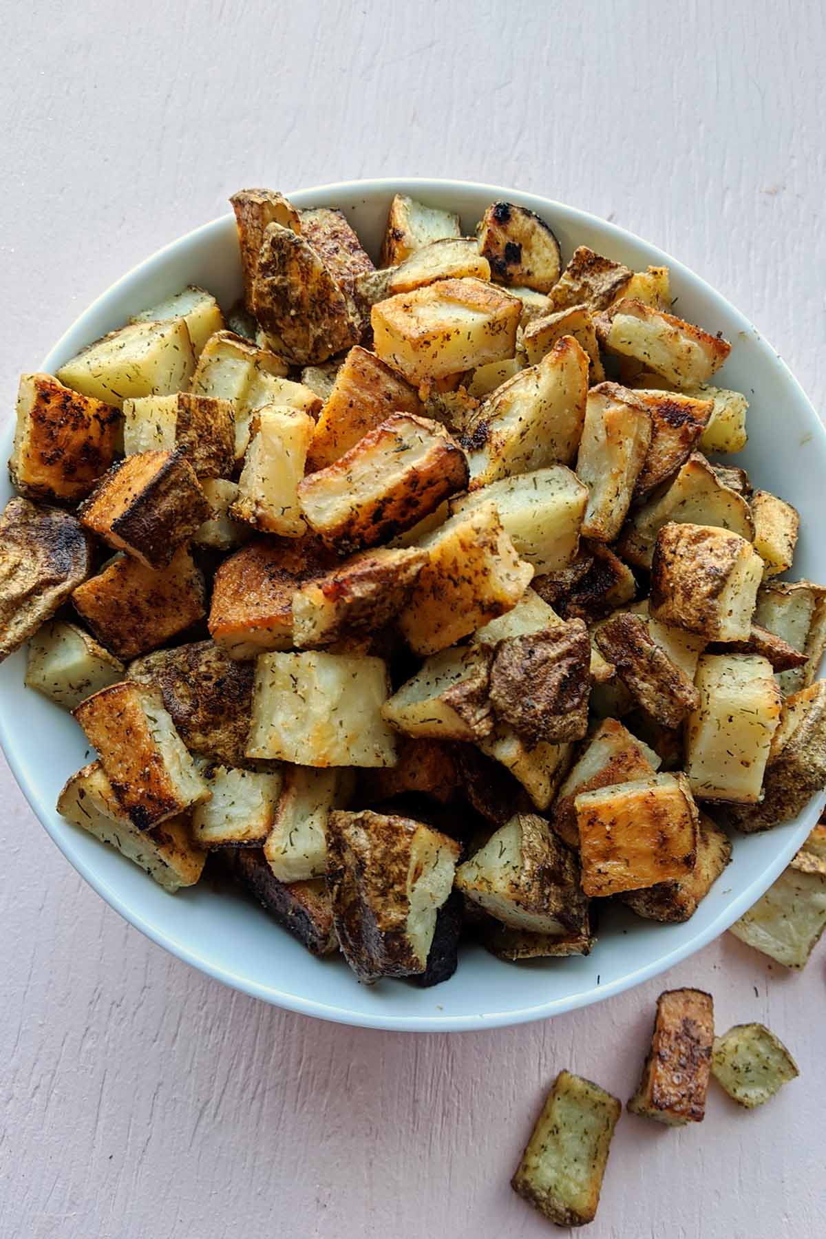 oven roasted russet potatoes in white serving bowl.
