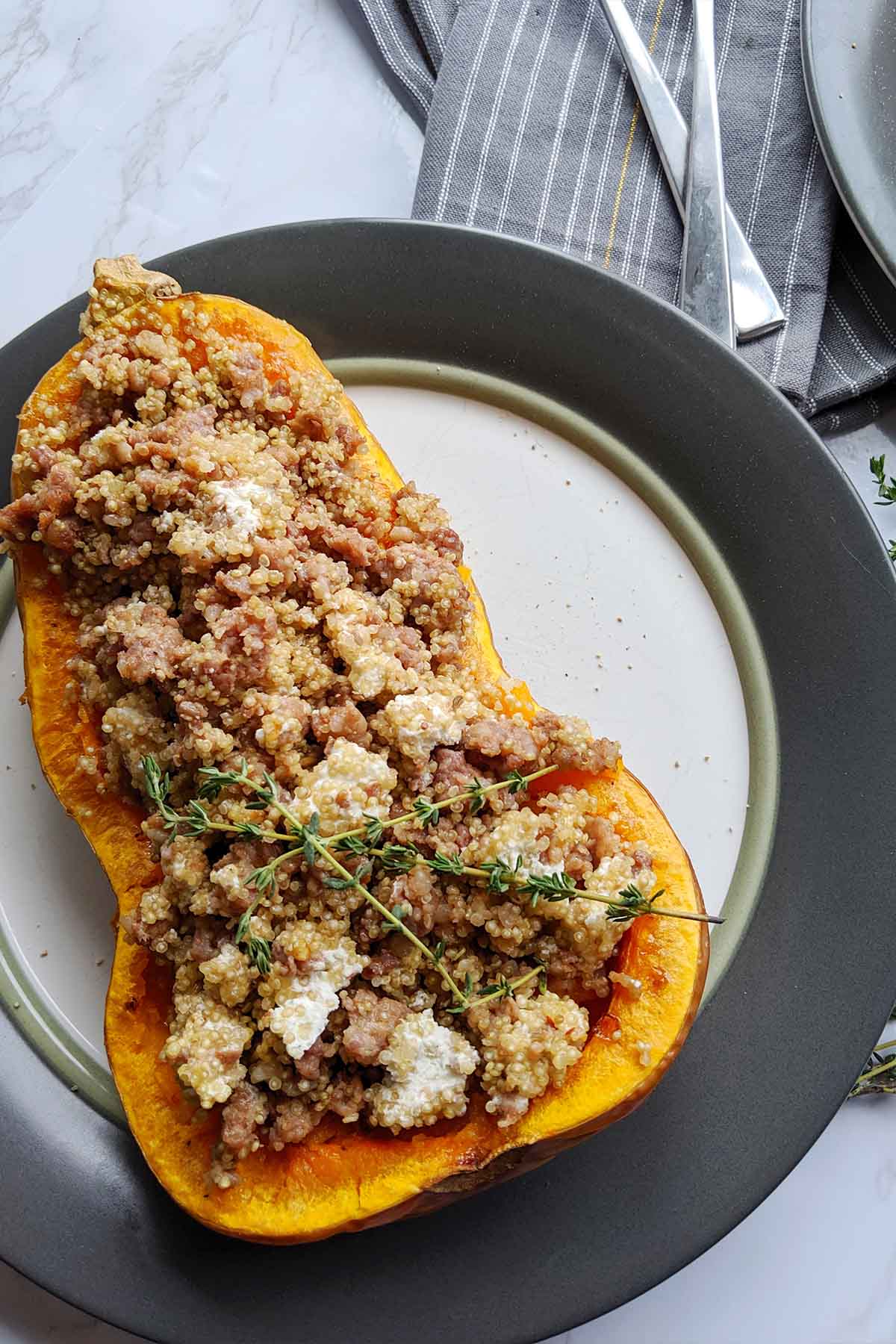 half of a butternut squash stuffed with cooked sausage, goat cheese, and quinoa.