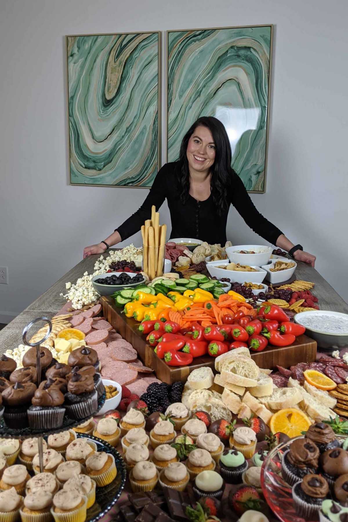 girl standing next to charcuterie grazing table.