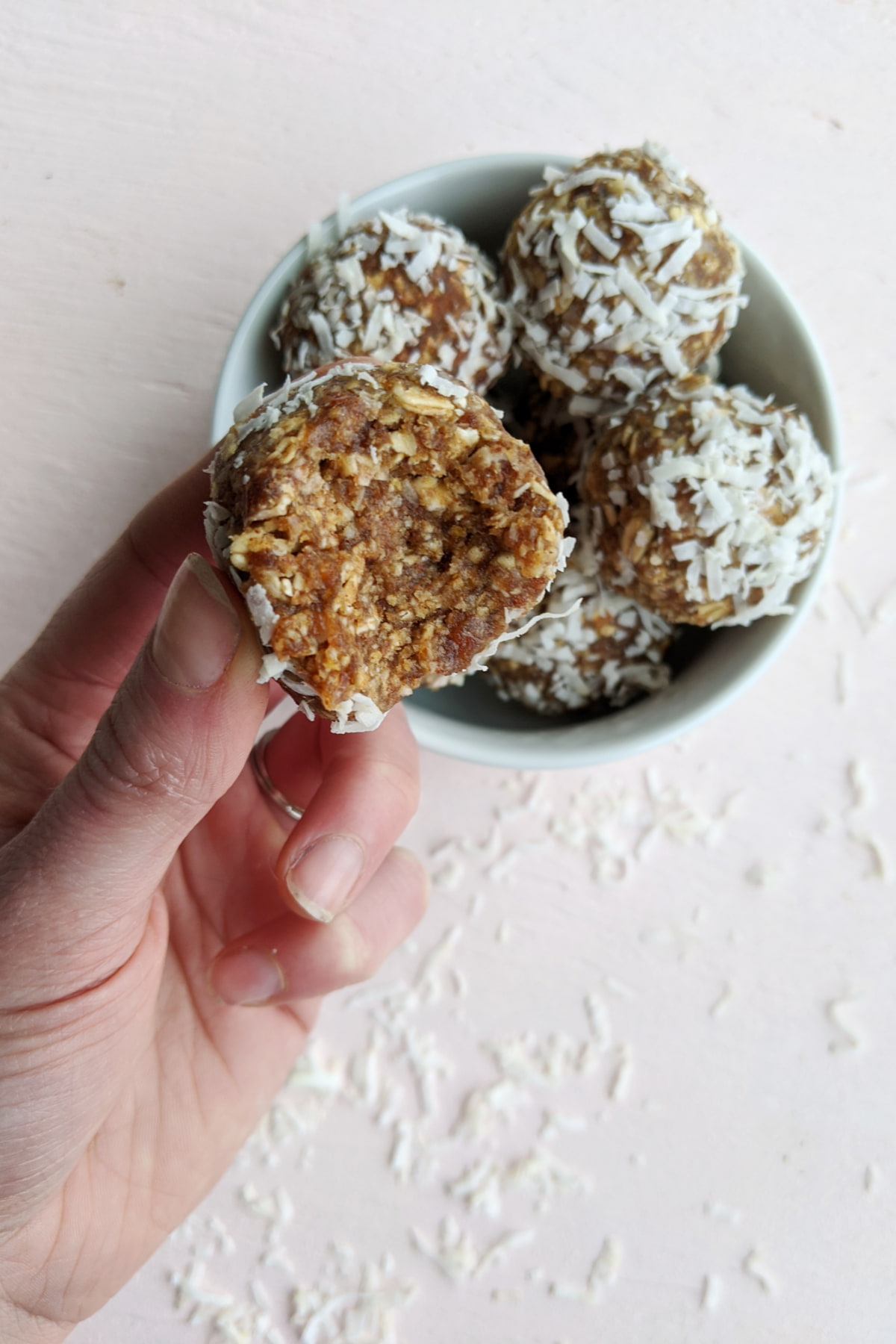 almond butter energy bites held in a hand.