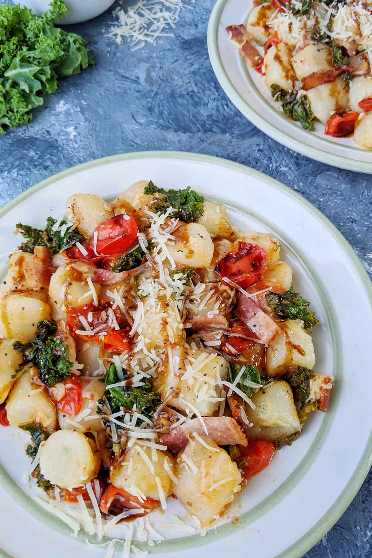 plate of gnocchi with kale and tomato.