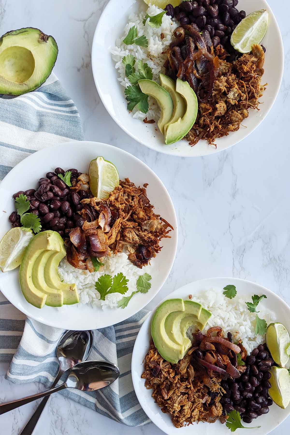 three bowls filled with shredded pork, beans, and rice.