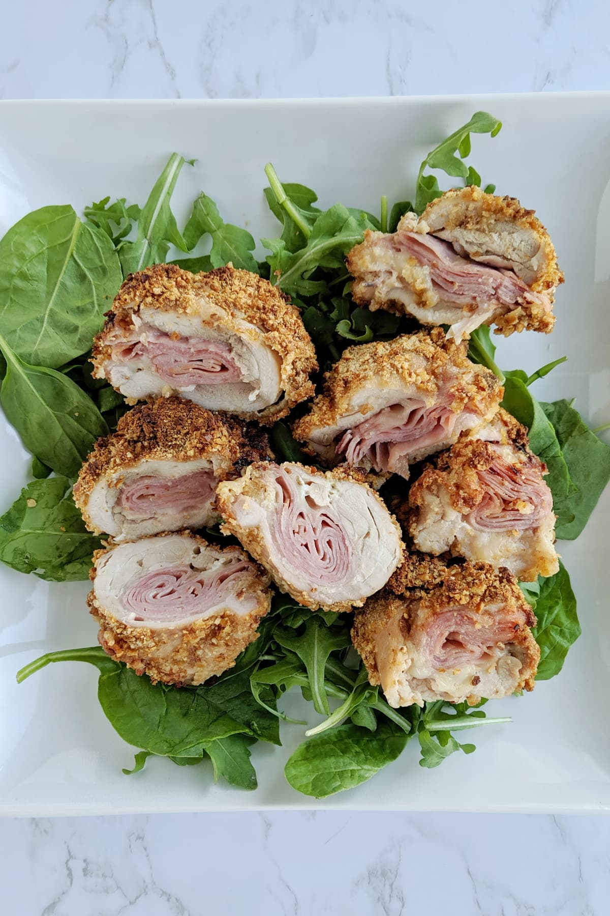 chicken cordon bleu on a bed of greens