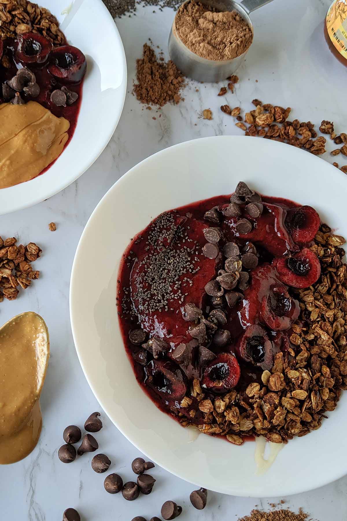 cherry smoothie bowl topped with chocolate granola.
