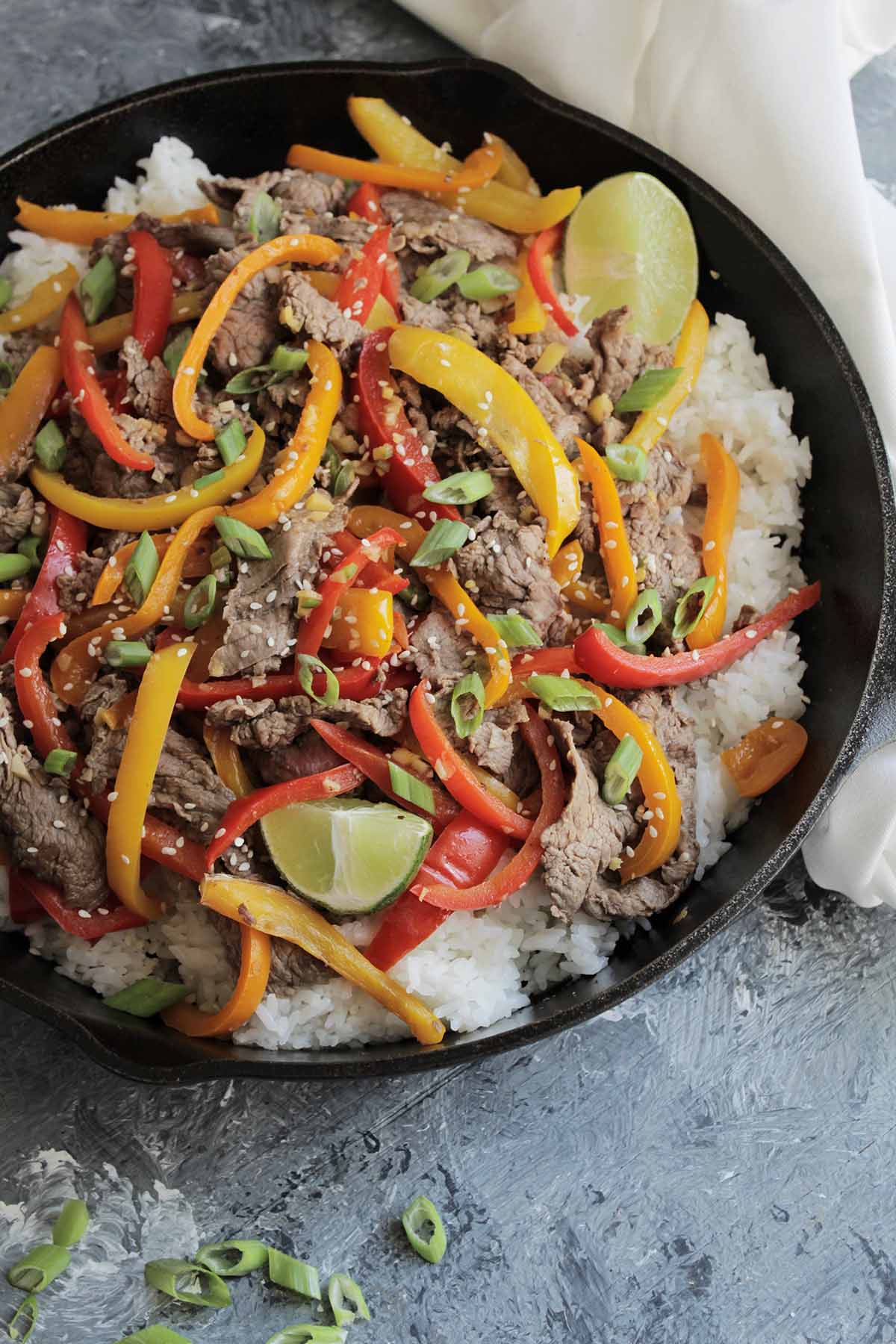 beef and peppers on a bed a white rice.