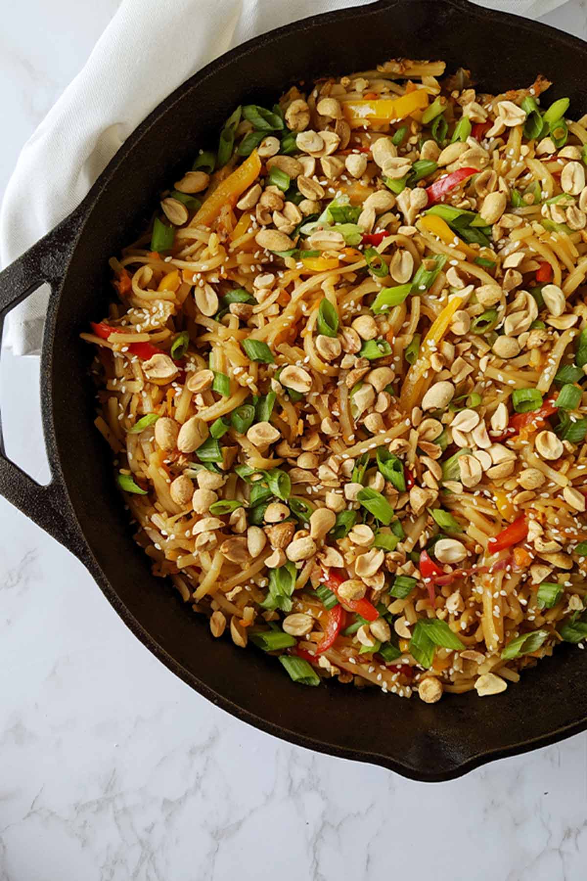 rice noodle stir fry in a cast iron skillet.