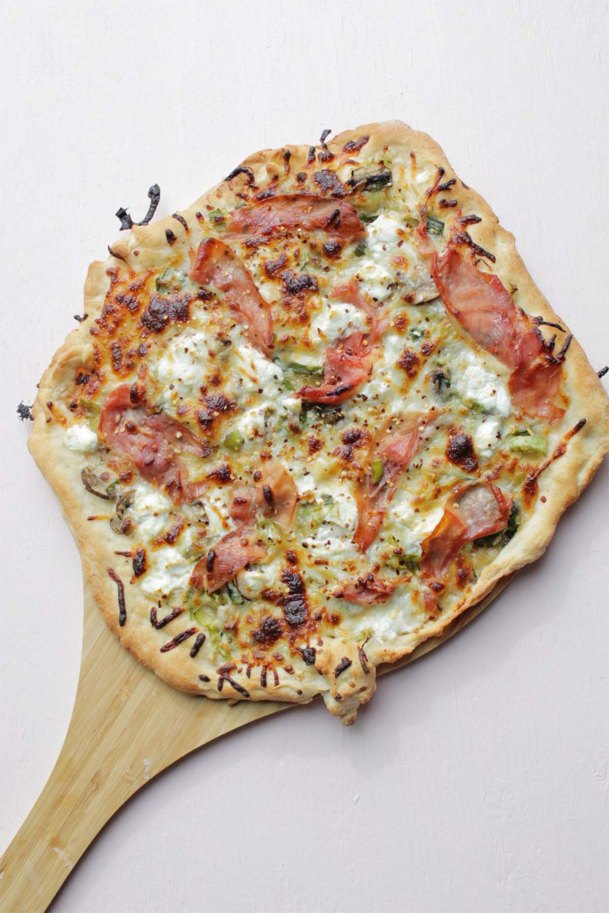 baked pizza on a wooden pizza peel.