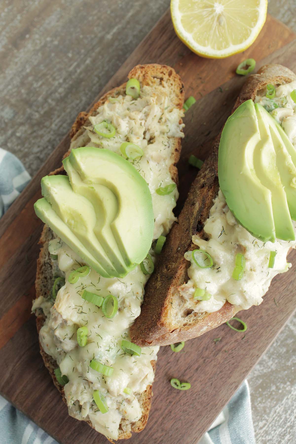 tuna melt on sourdough bread topped with avocado.