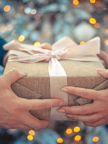 two hands holding a wrapped gift box.