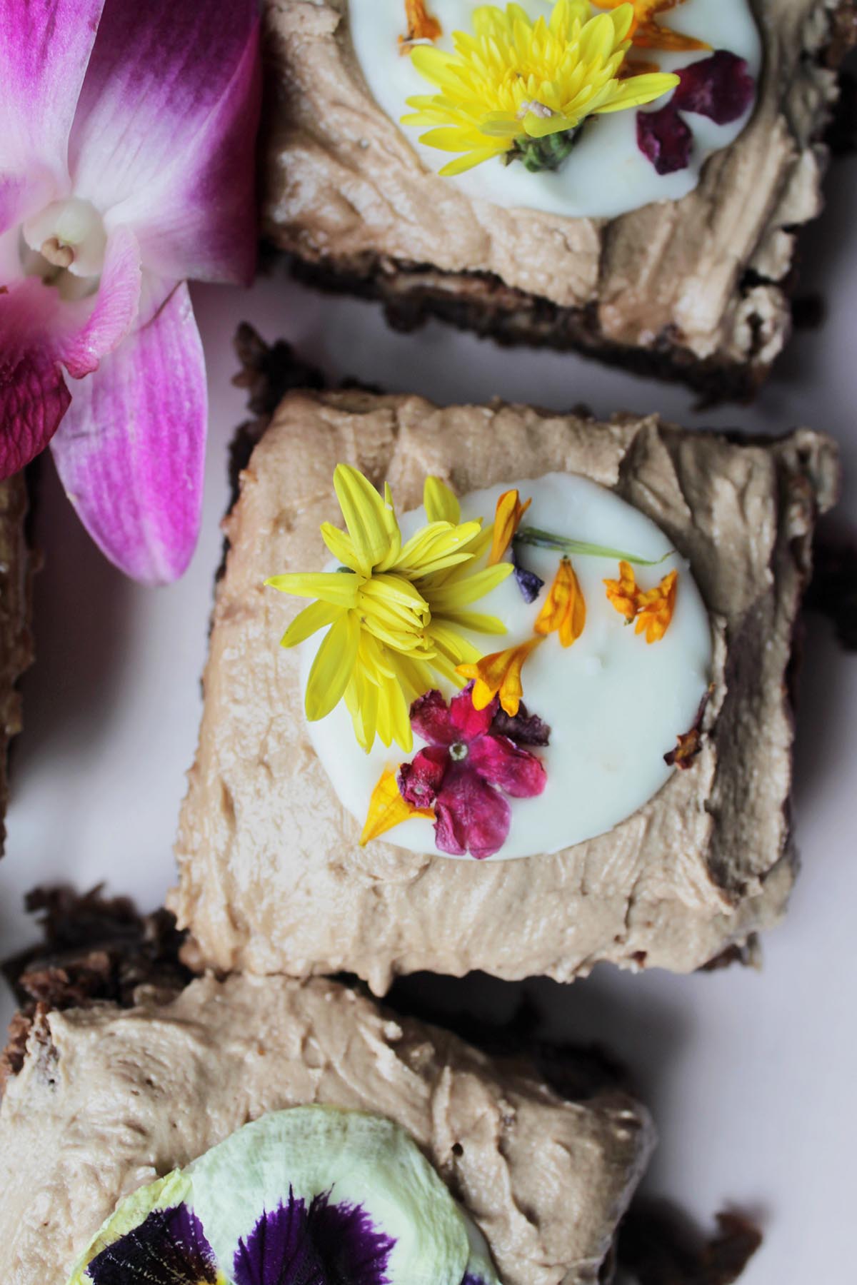 iced brownies decorated with edible flowers.