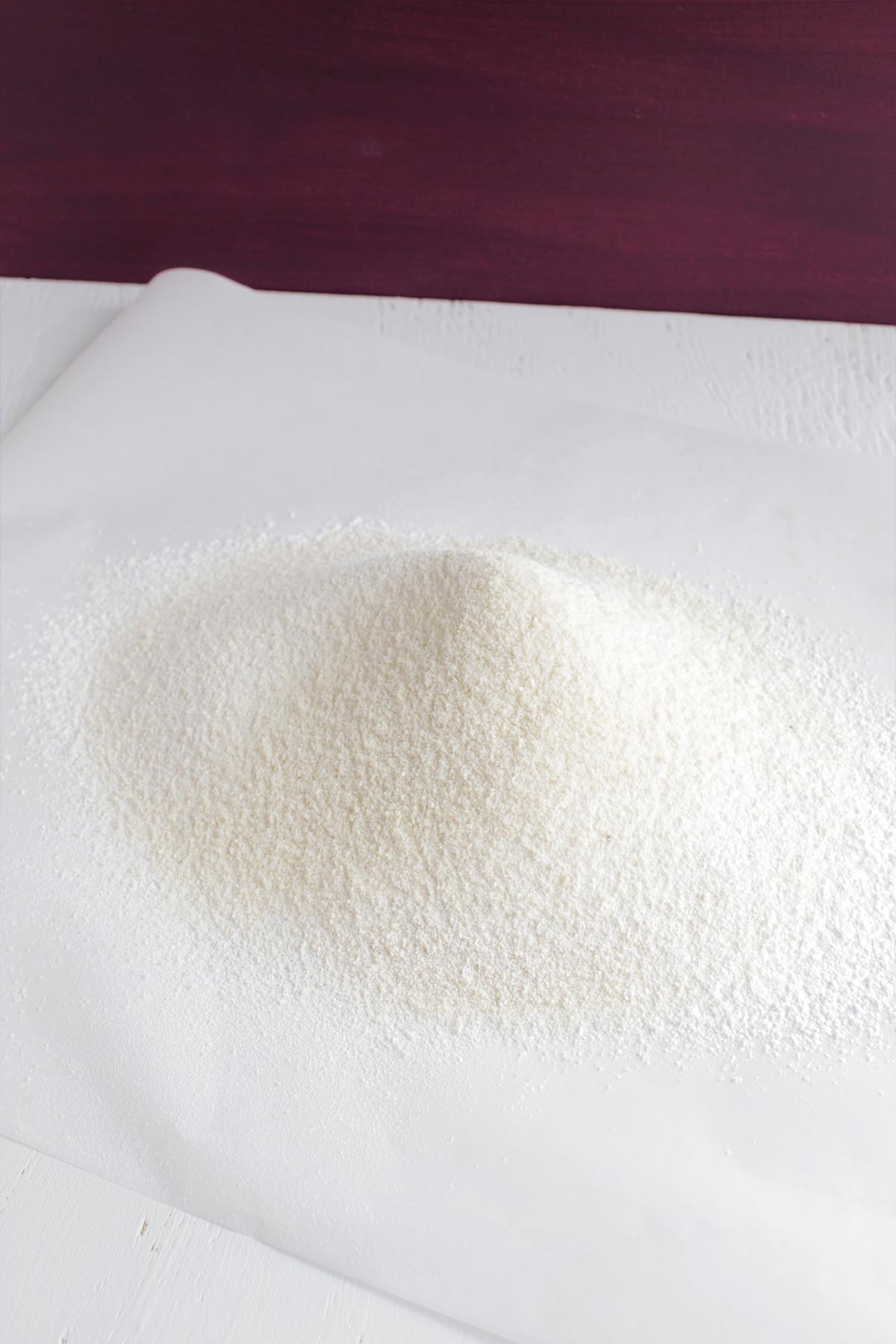 Sifted almost flour and confectioners' sugar on parchment paper.