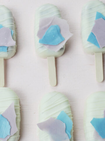 white chocolate cakesicles with blue and purple chocolate accents.