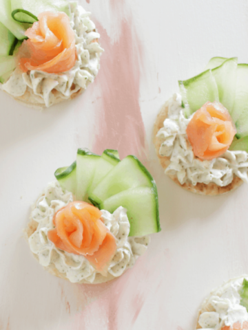 smoked salmon canapes on pink background.