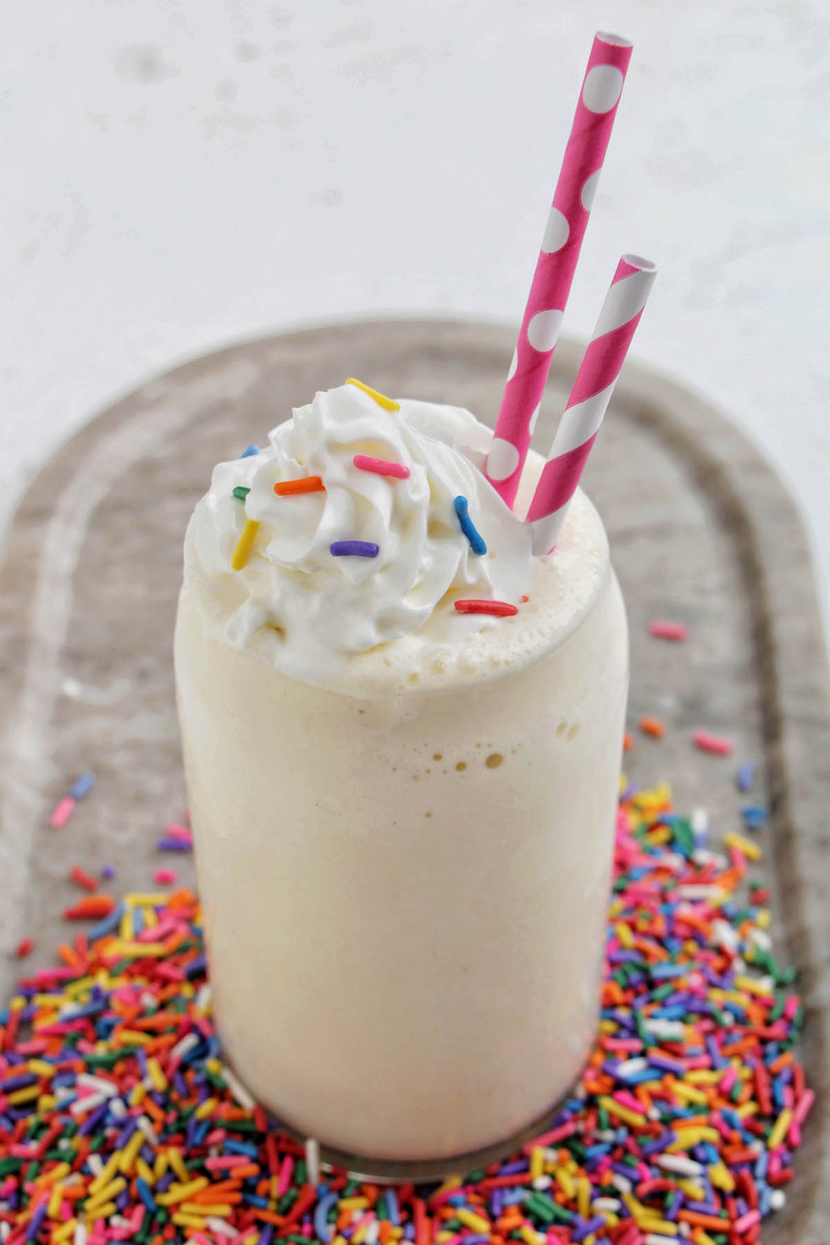 vanilla milkshake topped with whipped cream and sprinkles.