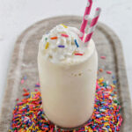 vanilla milkshake topped with whipped cream and sprinkles.