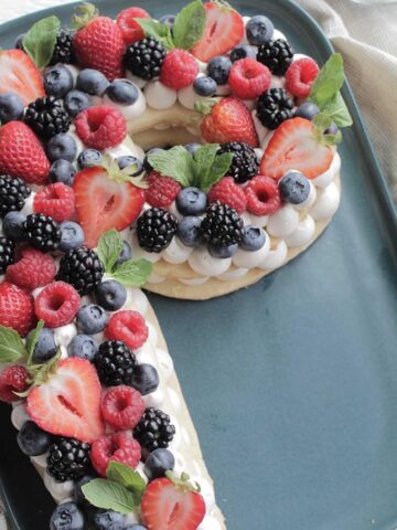 shortbread cookie cake topped berries in the shape of the letter P.