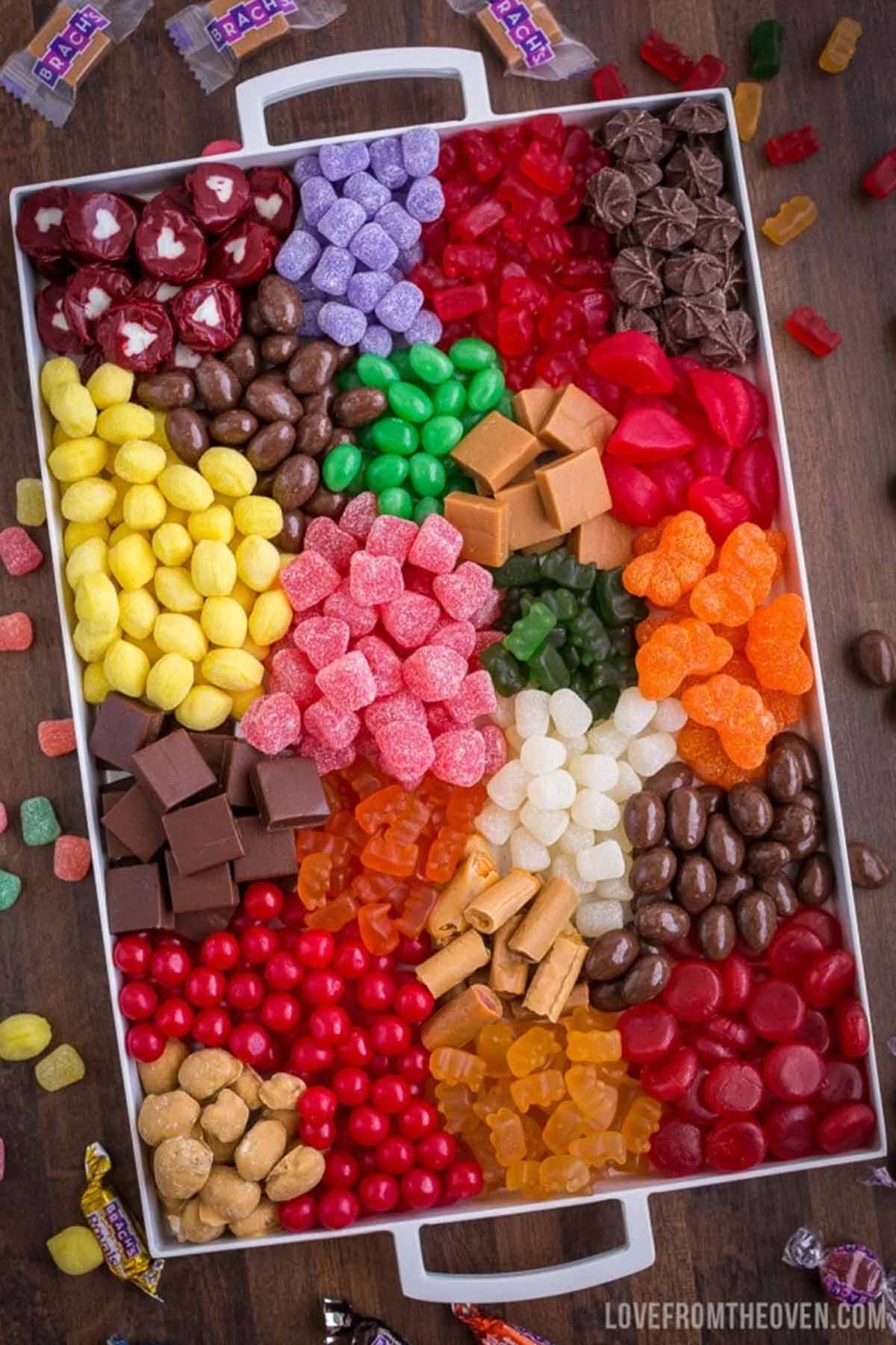 white serving tray filled with various types of candy.