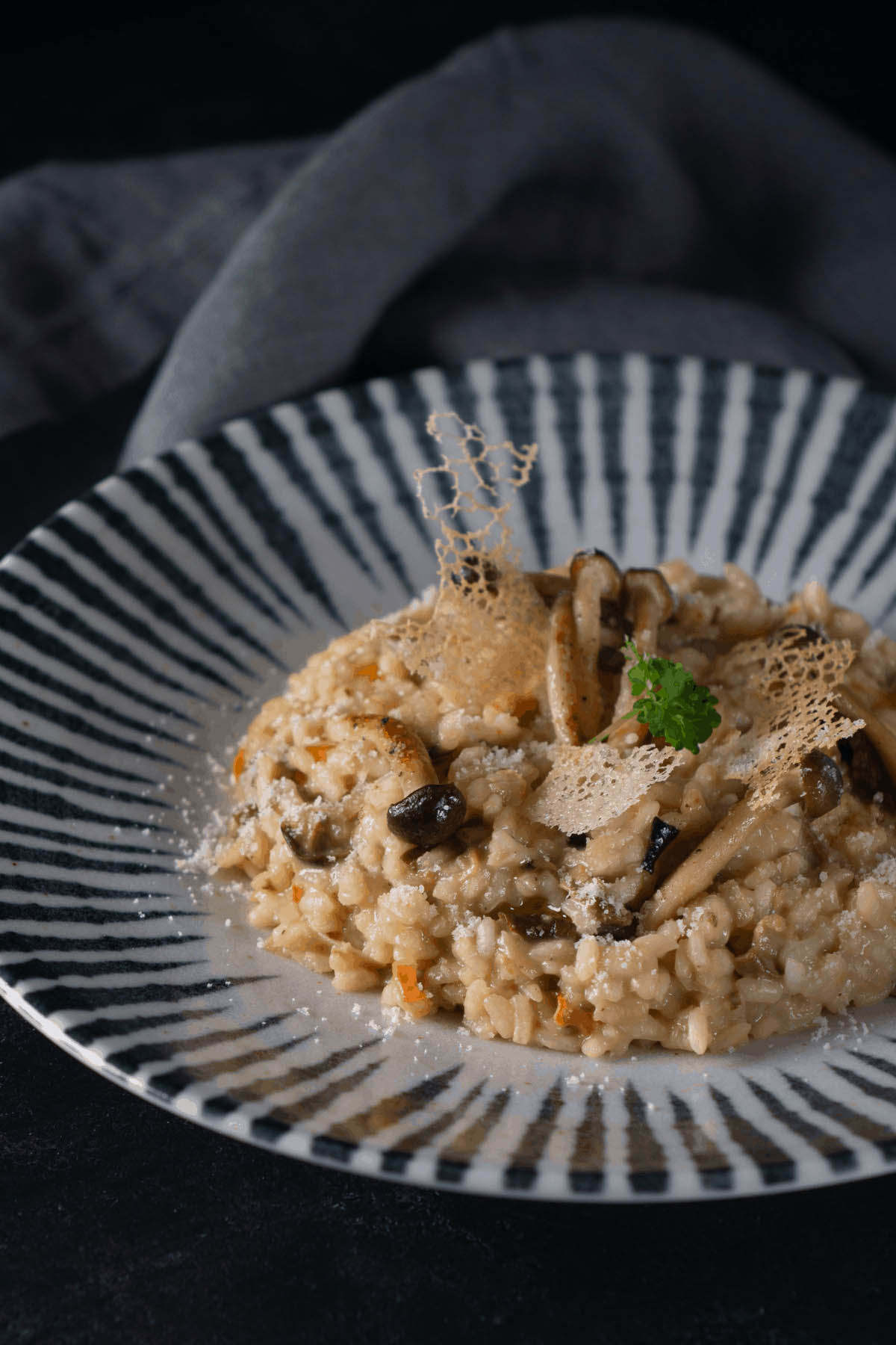 risotto plated on a striped bowl.