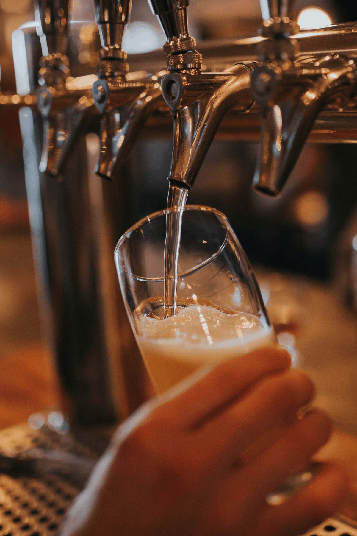 hand pouring beer from the tap.