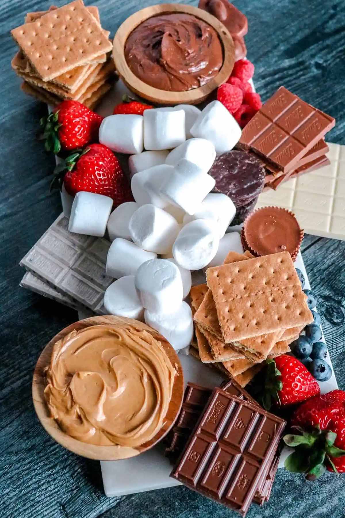 food board filled with chocolate, graham crackers, and marshmallows.