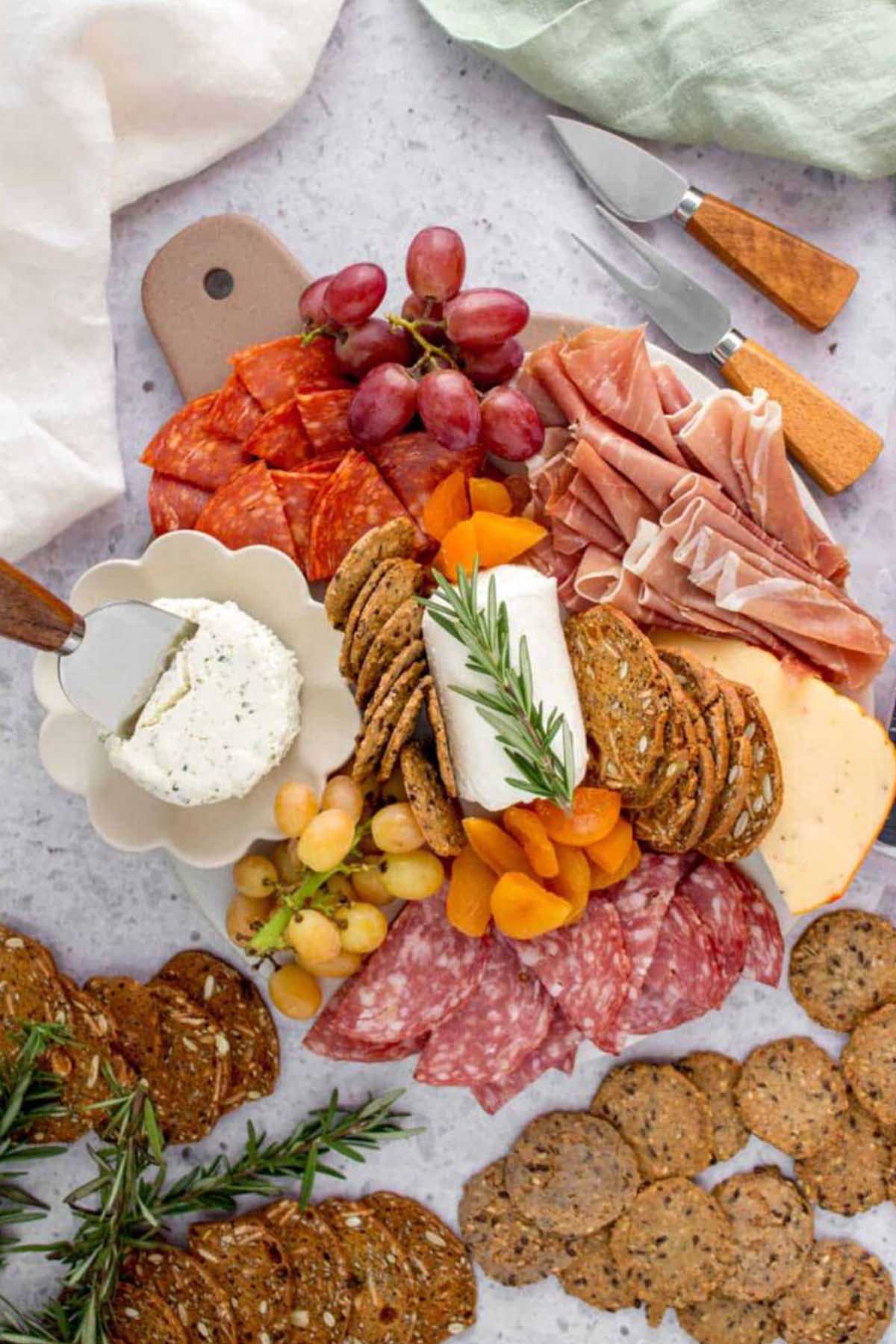 small serving board filled with cheese, meat, and crackers.