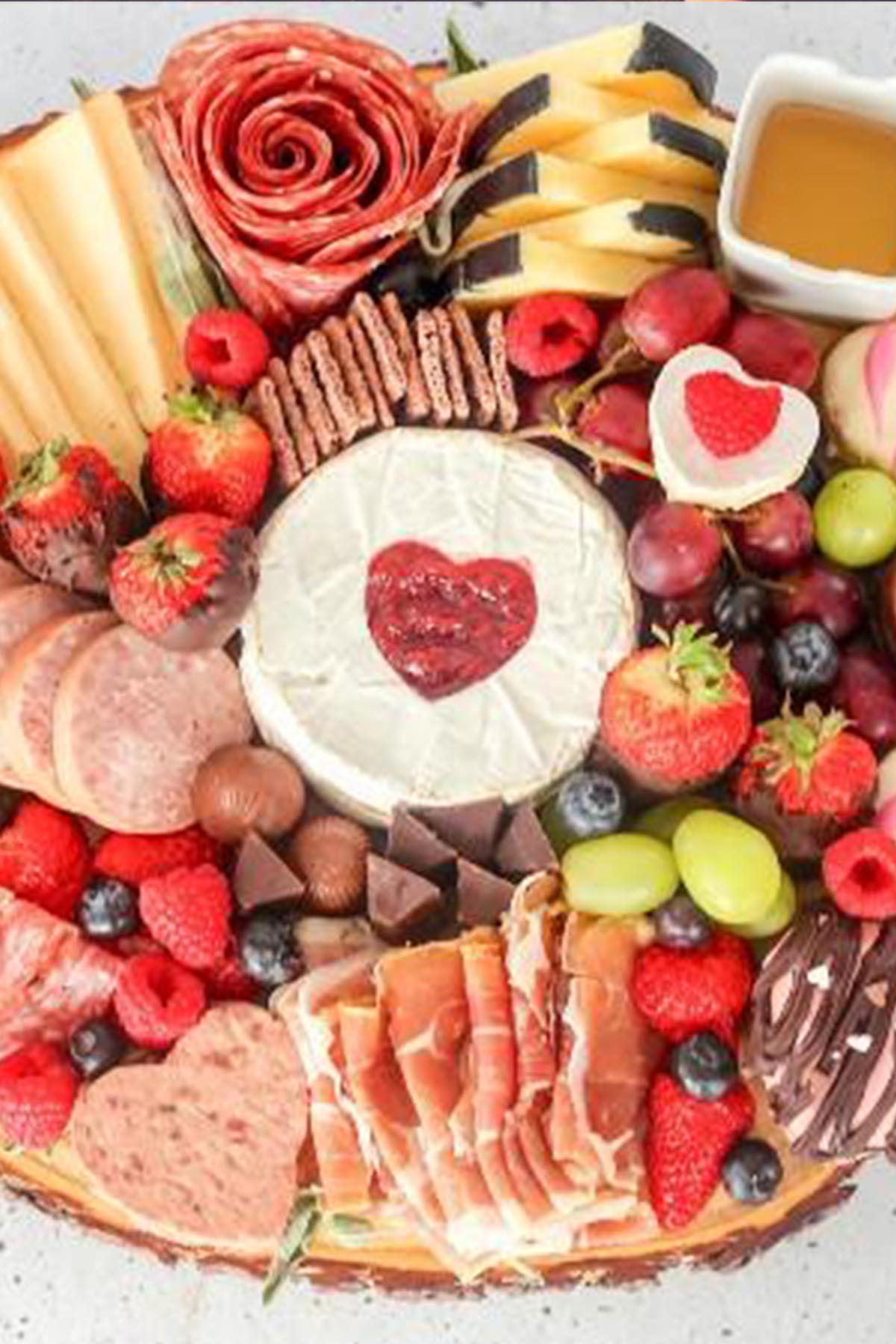 valentine's day charcuterie board with heart shaped brie cheese.