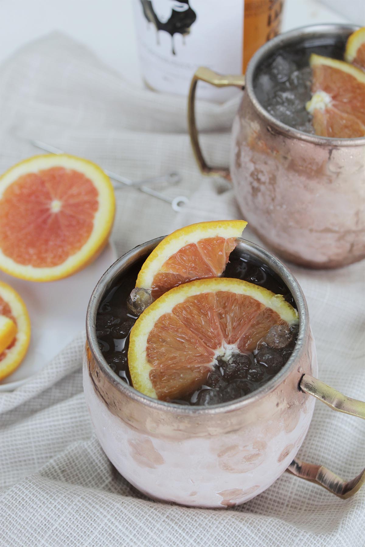 moscow mules in copper mug with orange slices.