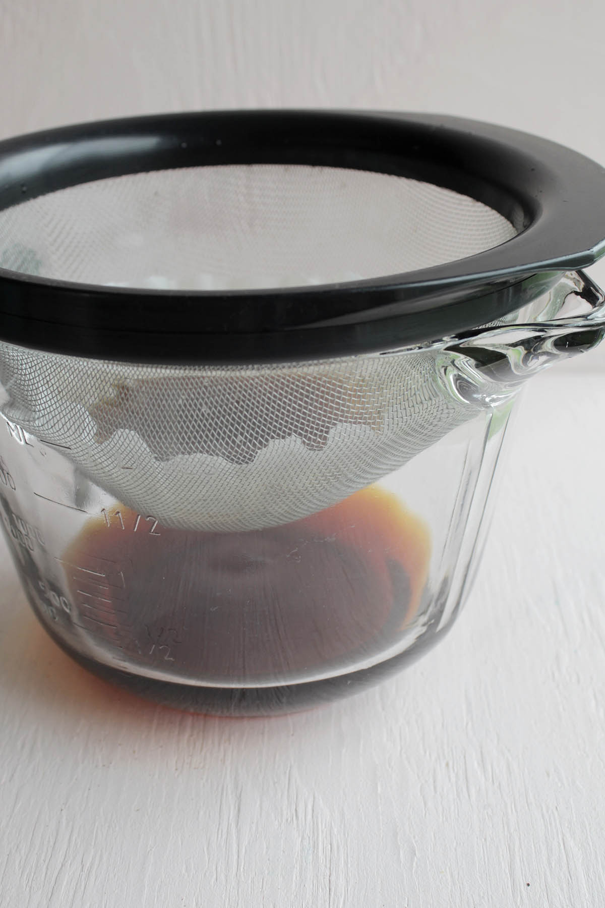 cold brew coffee draining into glass measuring cup.
