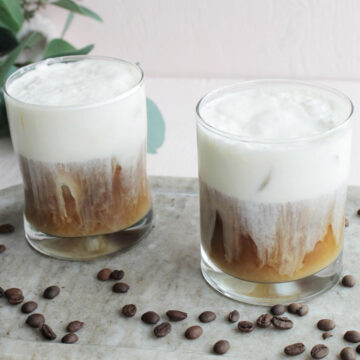 two lowball glasses with cold brew coffee topped with cold foam.