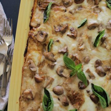 vegetable lasagna with mushrooms and basil on top