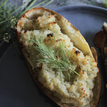 crispy twice baked potato with dill garnish.