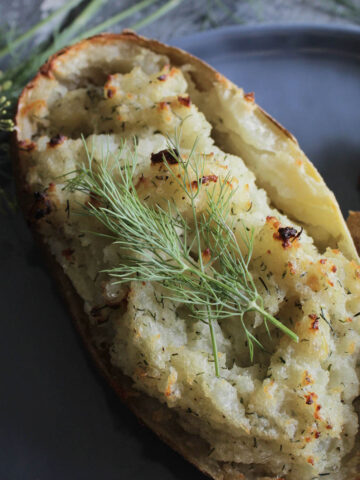 crispy twice baked potato with dill garnish.