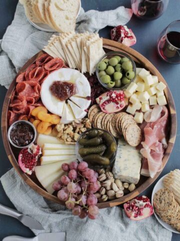 Thanksgiving cheese board on circular wooden platter.