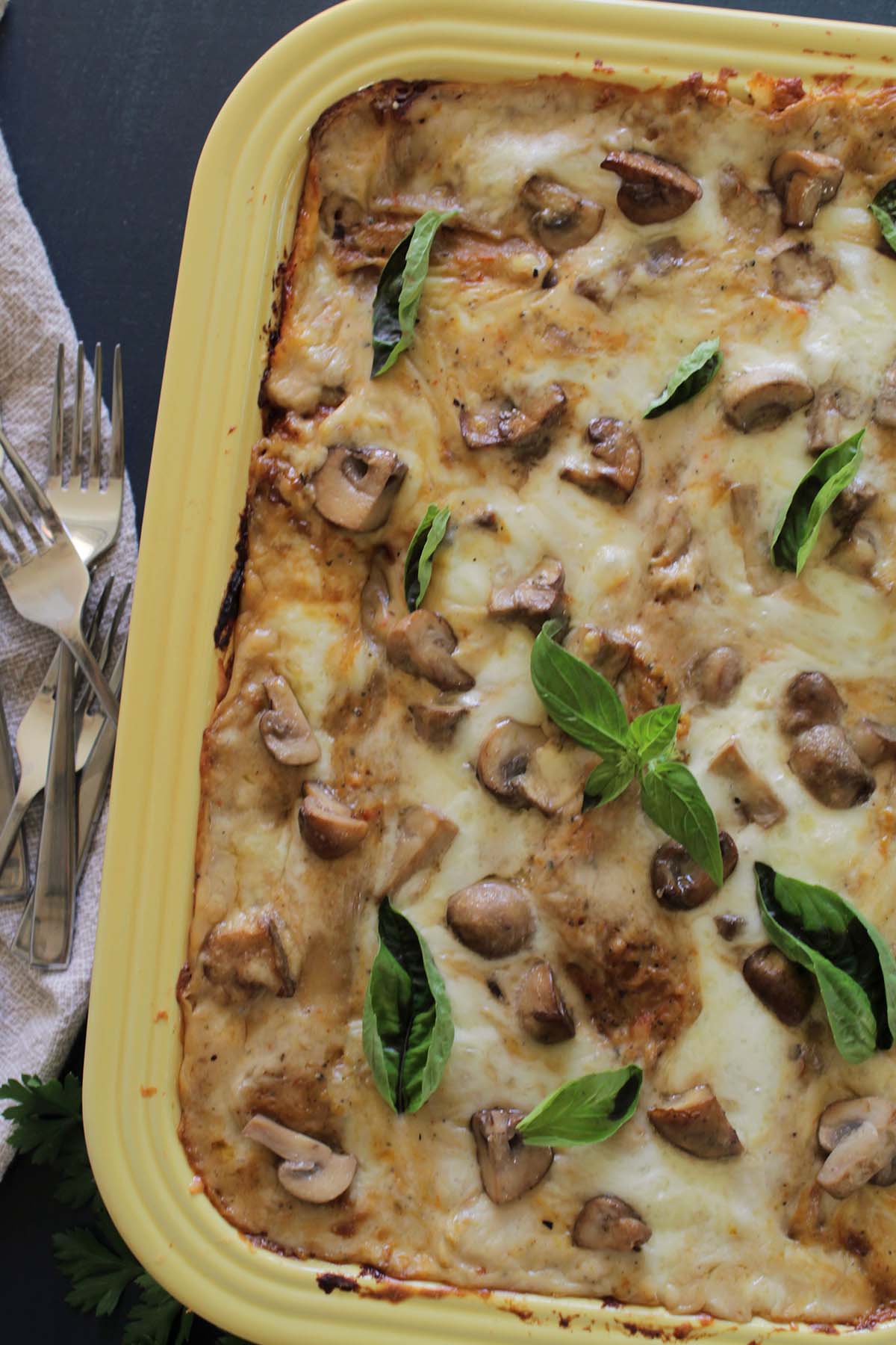 vegetable lasagna with mushrooms and basil on top