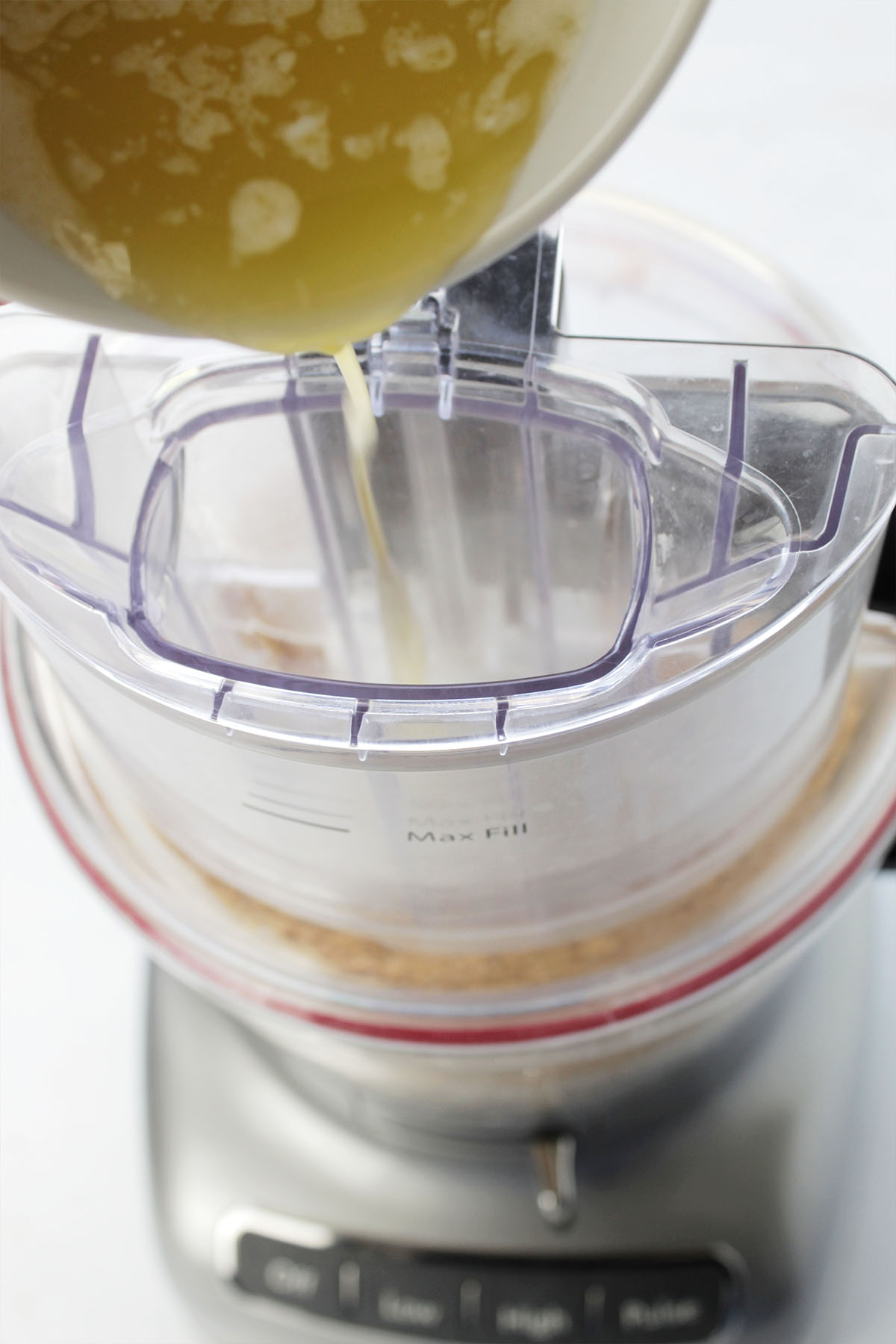 pouring melted butter into food processor