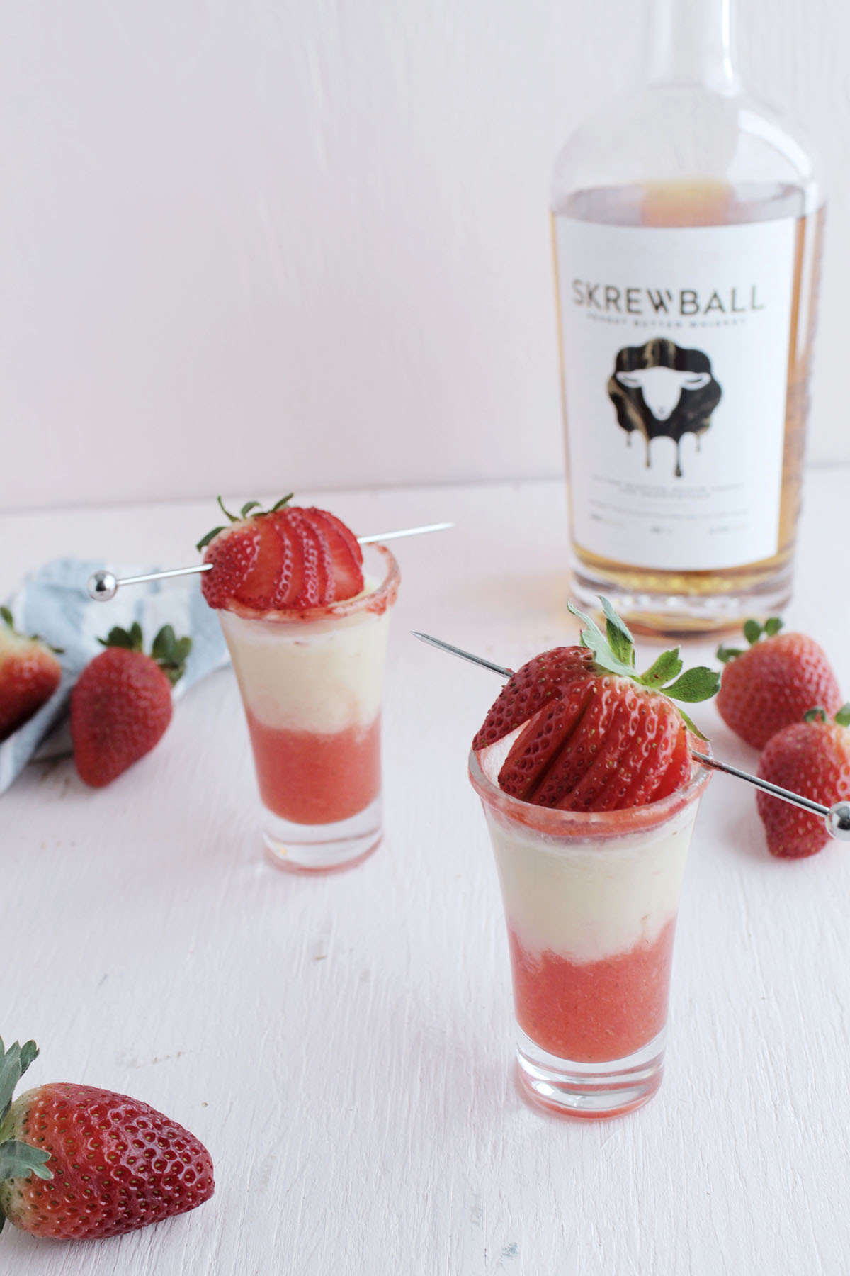 skrewball shot recipe with strawberry garnish