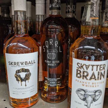 Skrewball, Sqrrl, and Skatterbrain alcohol bottles on store shelf.