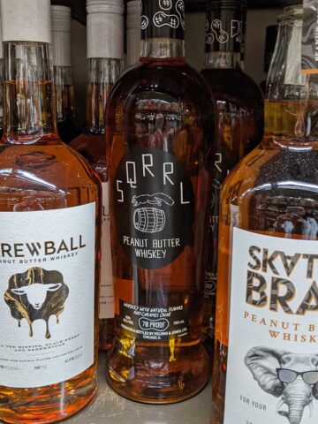 Skrewball, Sqrrl, and Skatterbrain alcohol bottles on store shelf.