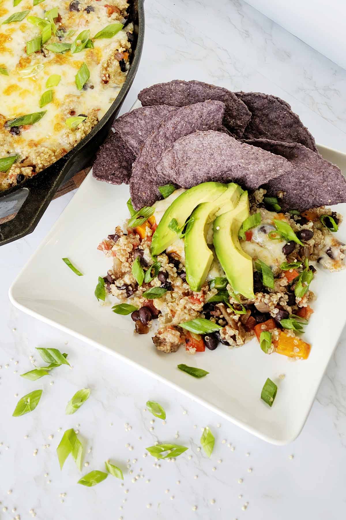 Vegetarian quinoa bake topped with avocado and tortilla chips