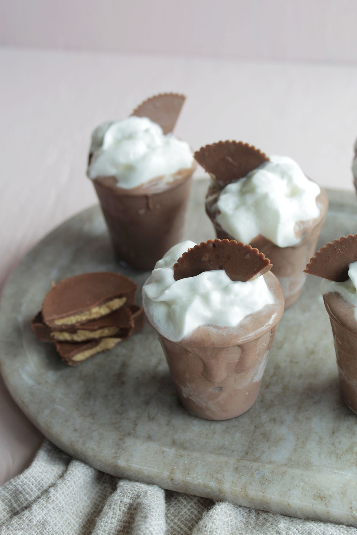 peanut butter whiskey pudding shots garnished with whipped cream.