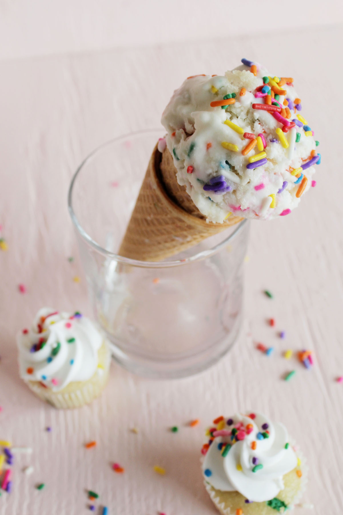 birthday cake ice cream on cone next to mini cupcakes