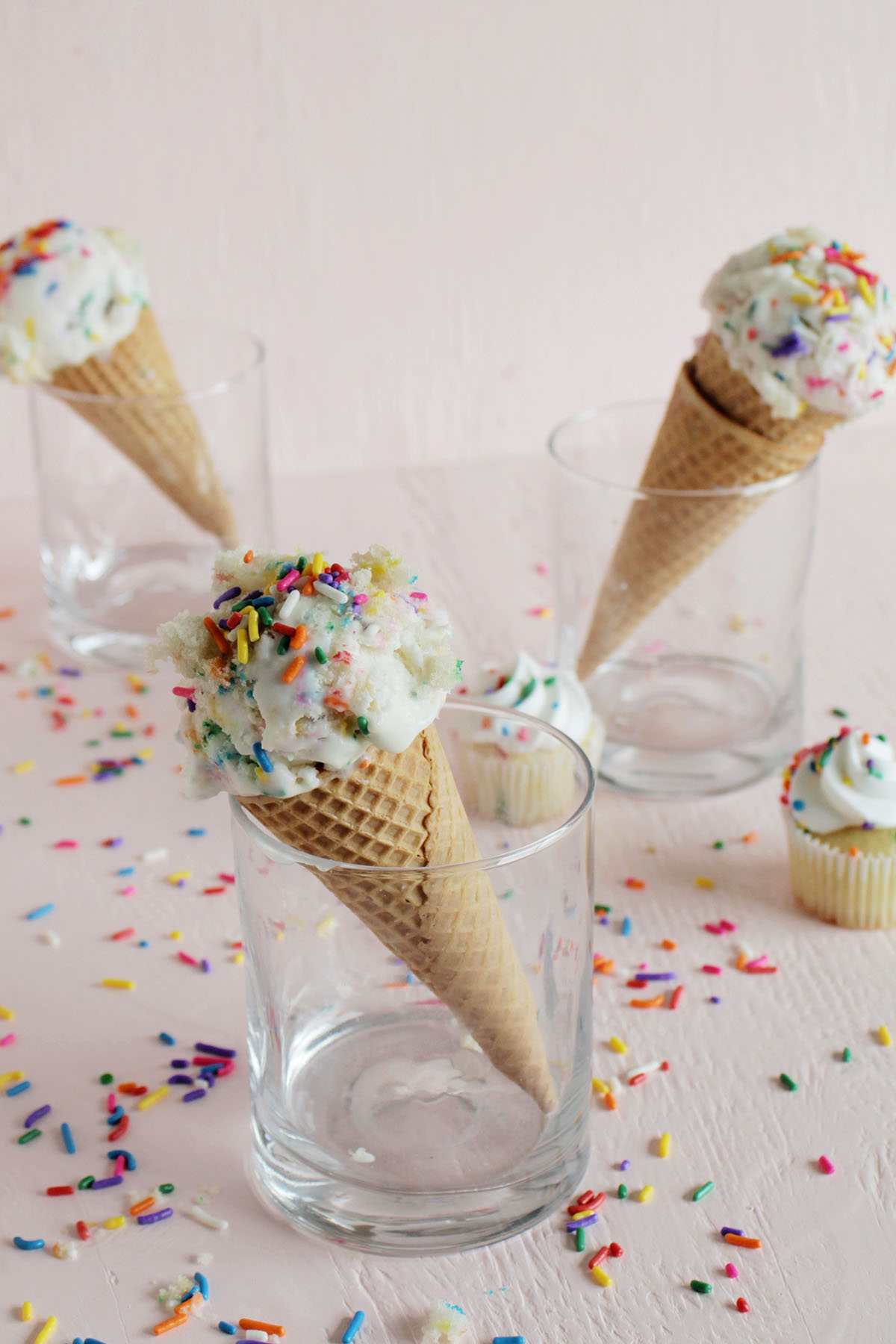 three ice cream cones with rainbow sprinkles