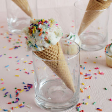 vanilla ice cream with rainbow sprinkles on ice cream cone.