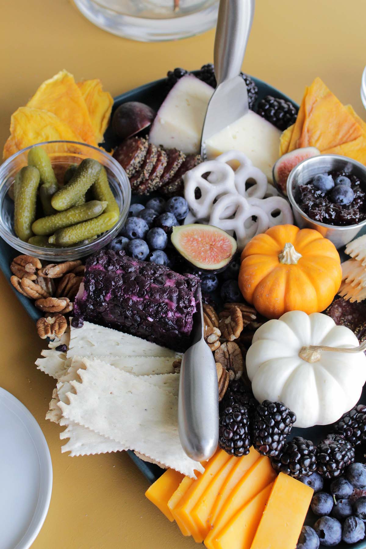 cheese board with fruit, cheese, and crackers.