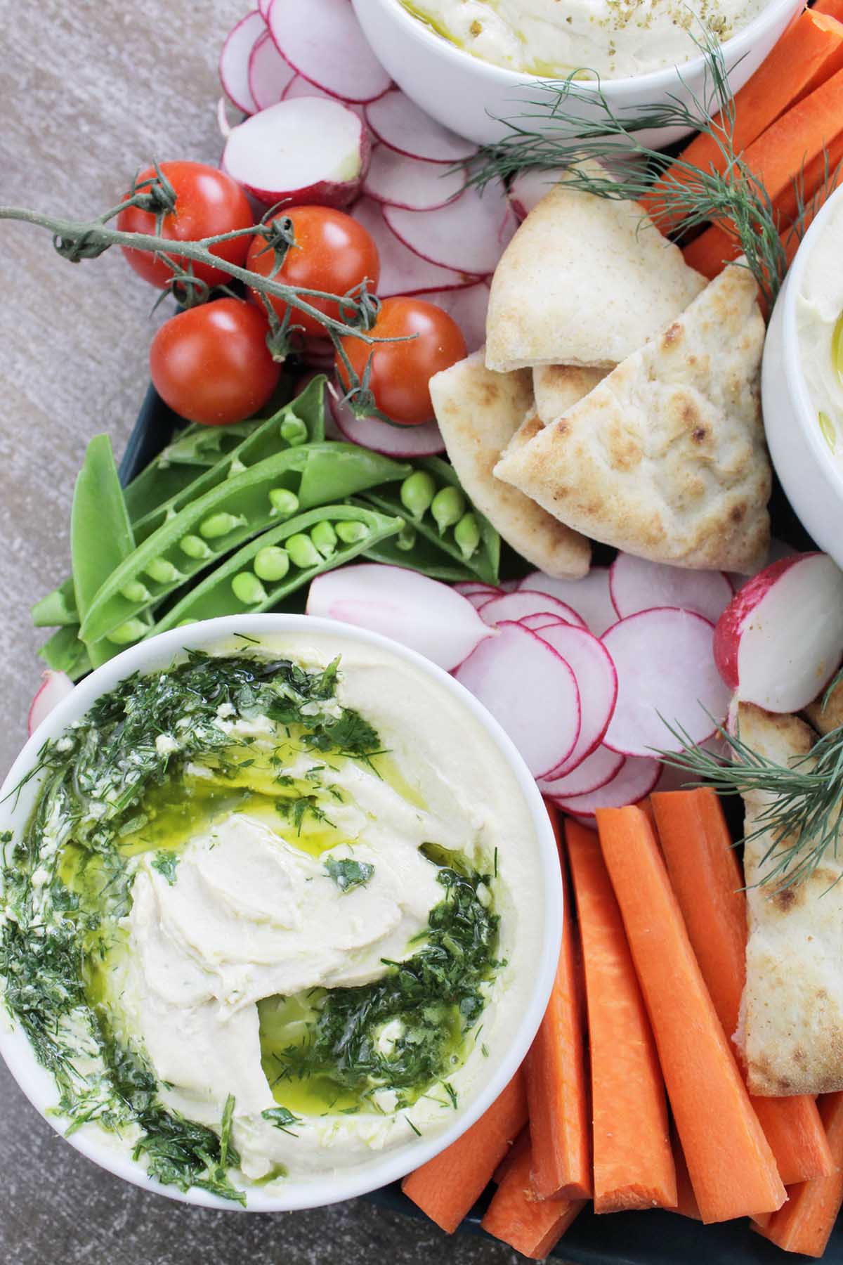 herbed hummus next to vegetables and pita