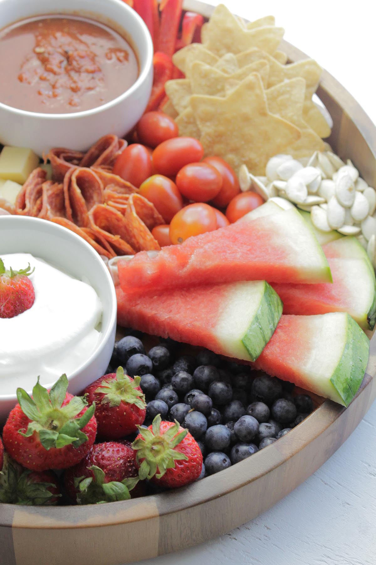cheese board with fruit, star tortilla chips and dips.