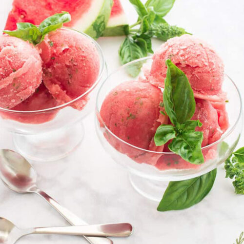 watermelon and basil sorbet in glass serving bowl.