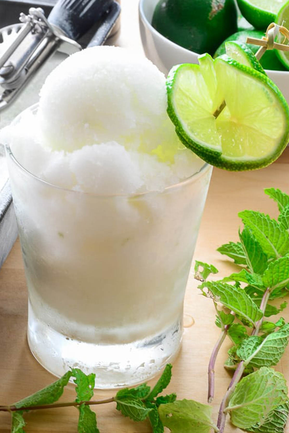 alcoholic sorbet in serving glass with lime garnish.