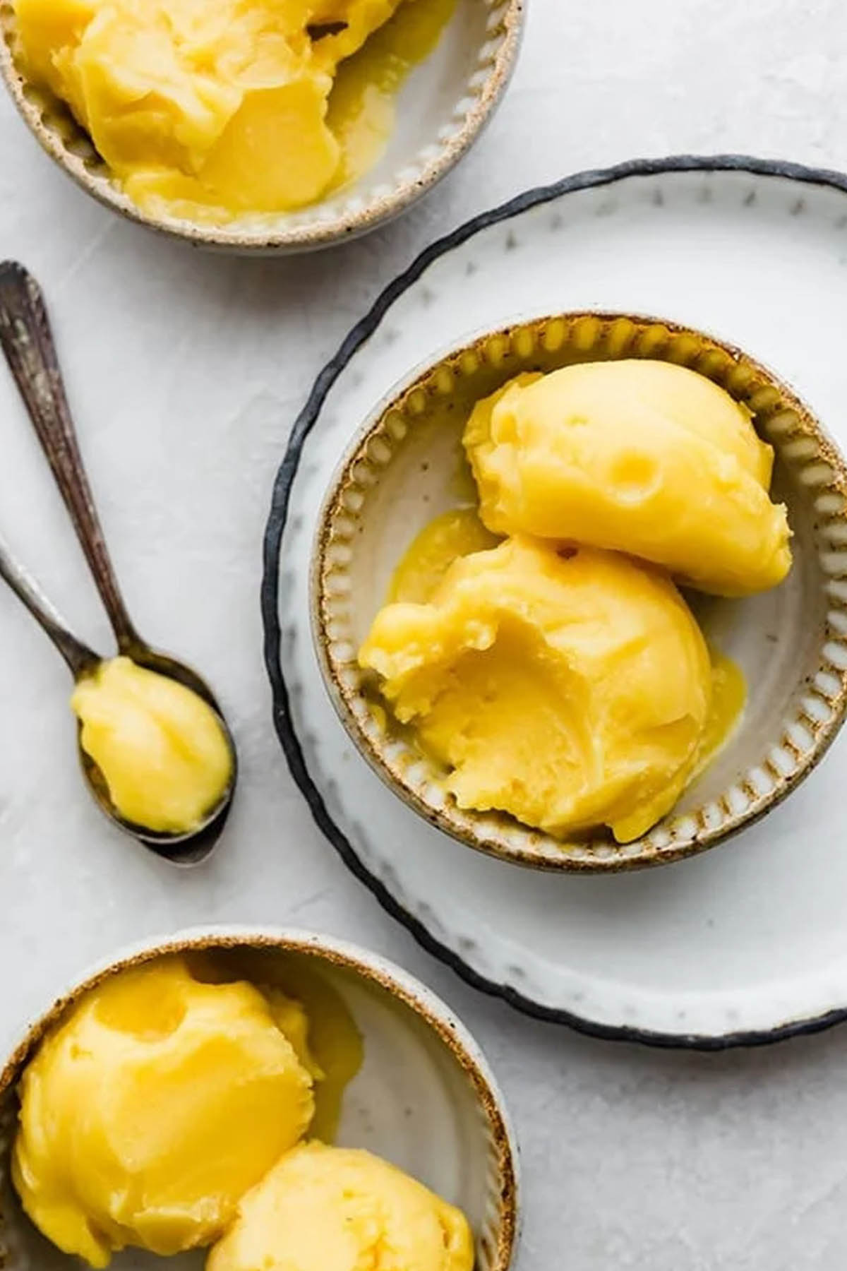 mango sorbet recipe scooped in serving bowl.