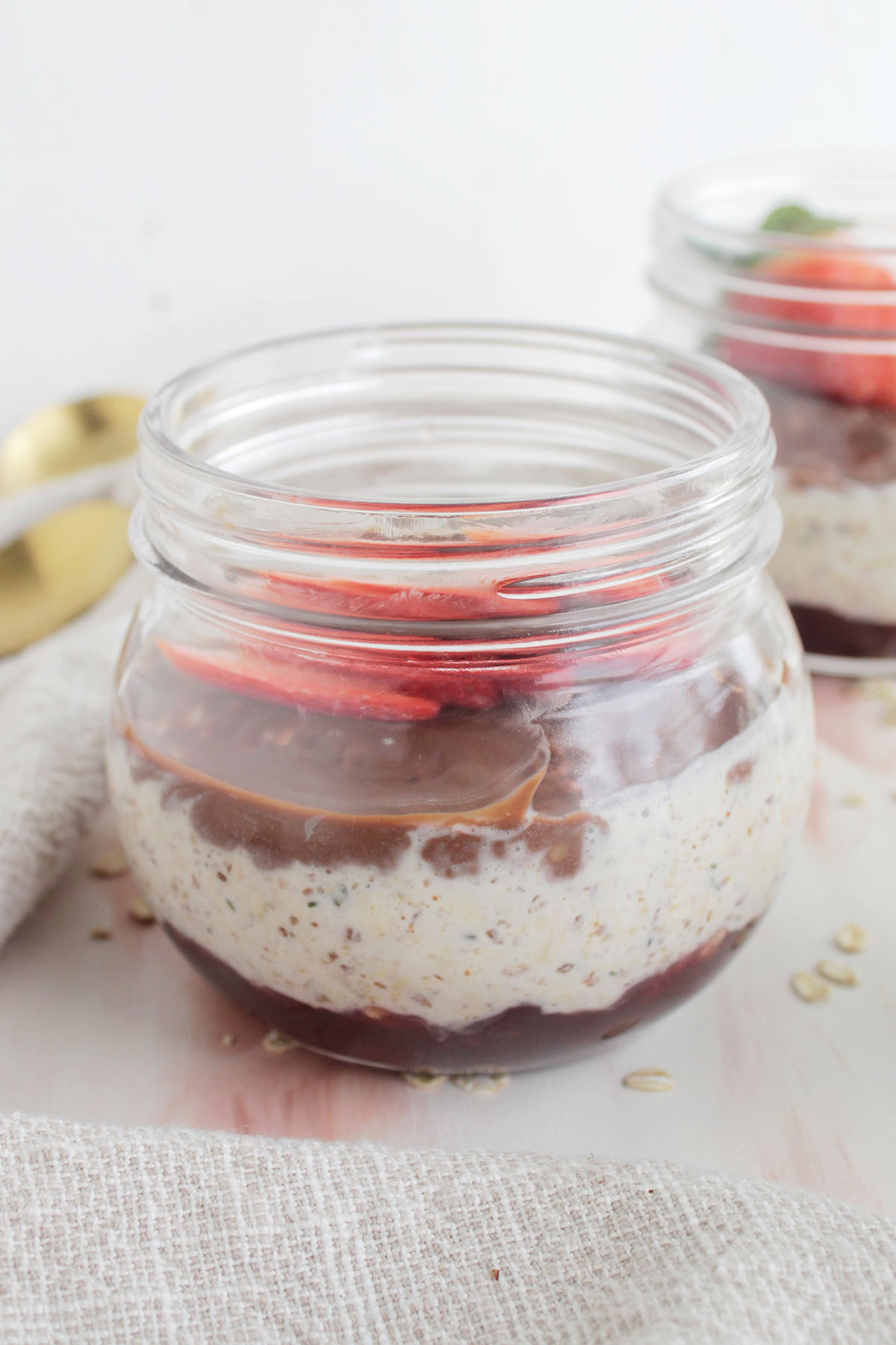 overnight oats layered with strawberry jam and chocolate topping.